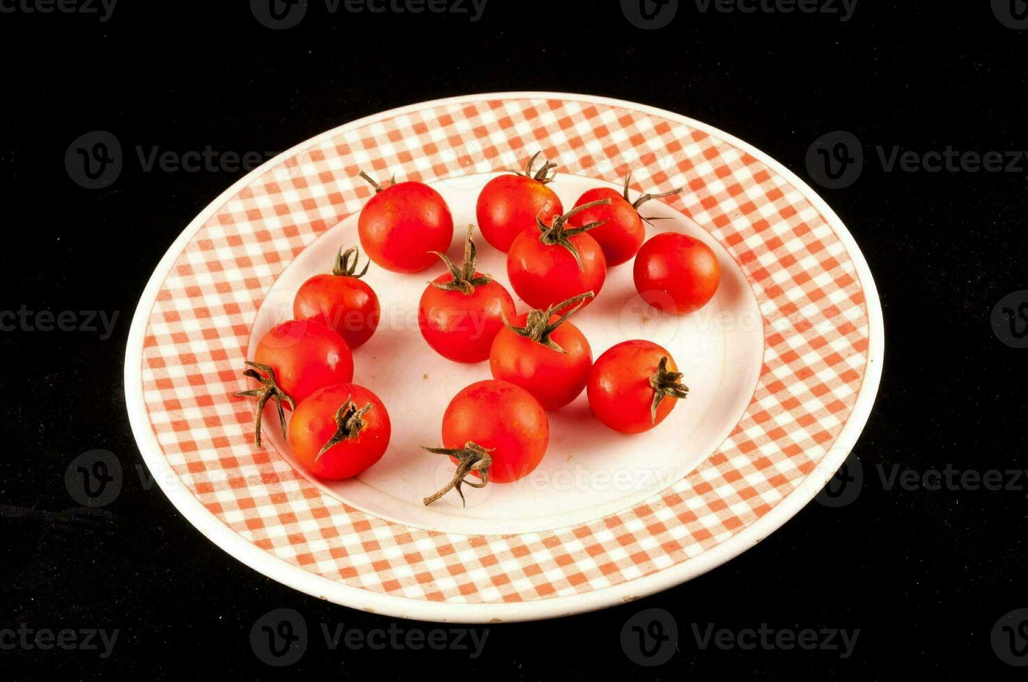 a plate with a checkered pattern has tomatoes on it photo