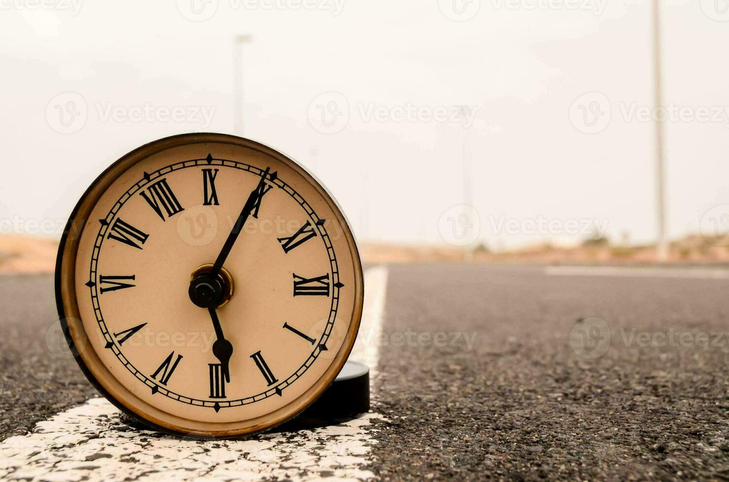 a clock in the middle of the road photo