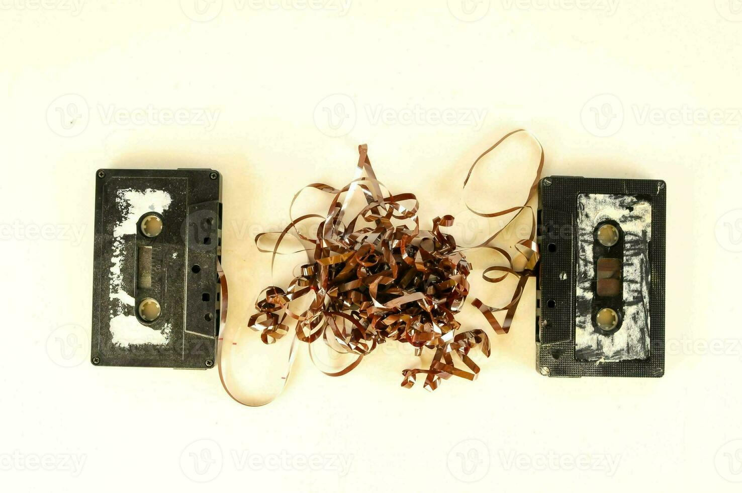 two old cassettes on a white surface photo