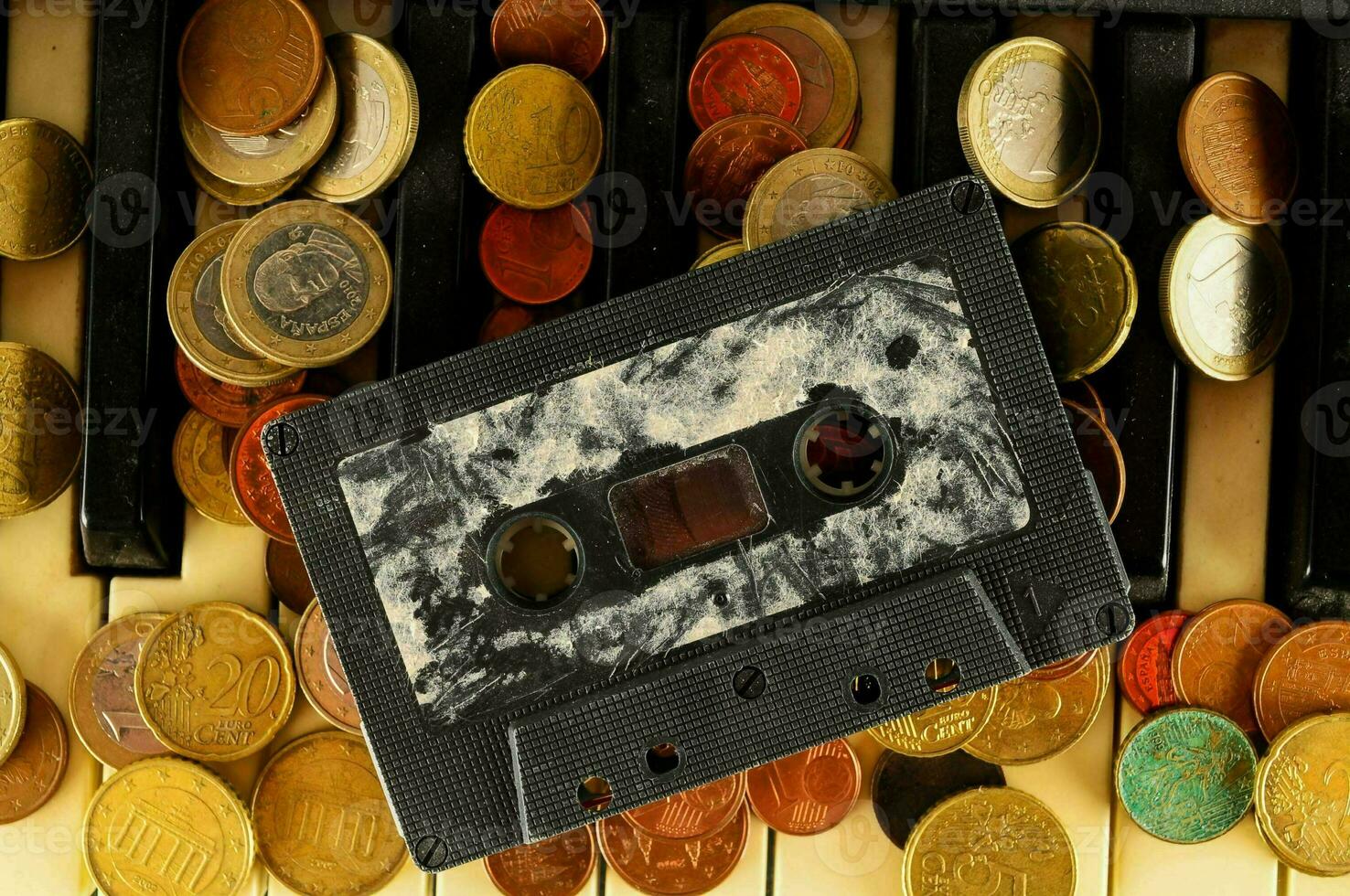 a cassette with coins on top of a piano photo