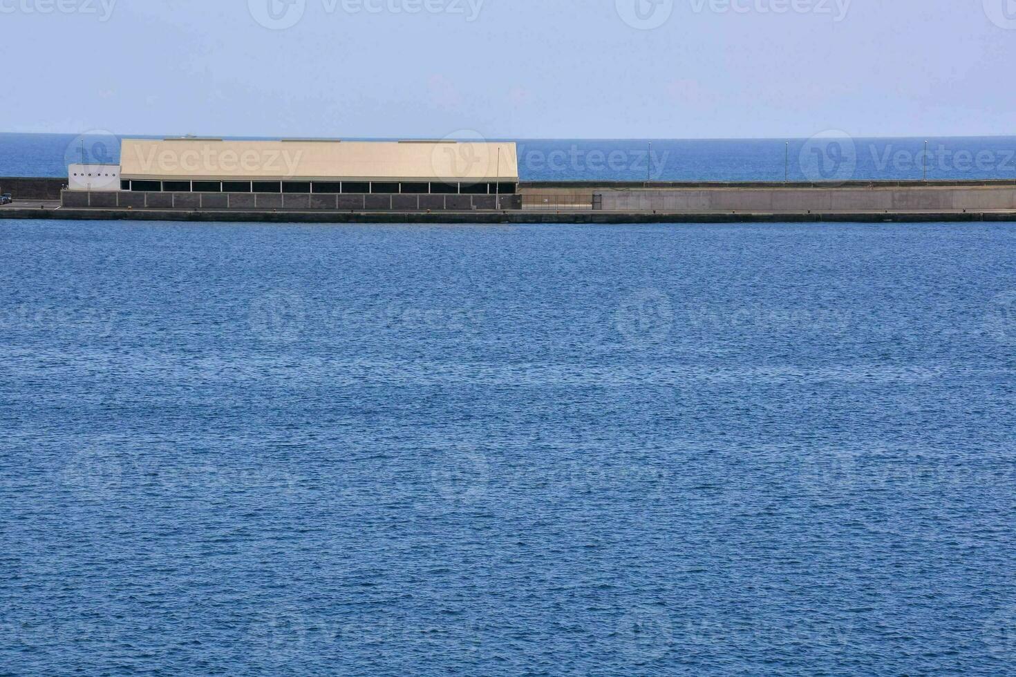 un grande edificio sentado en parte superior de un grande cuerpo de agua foto