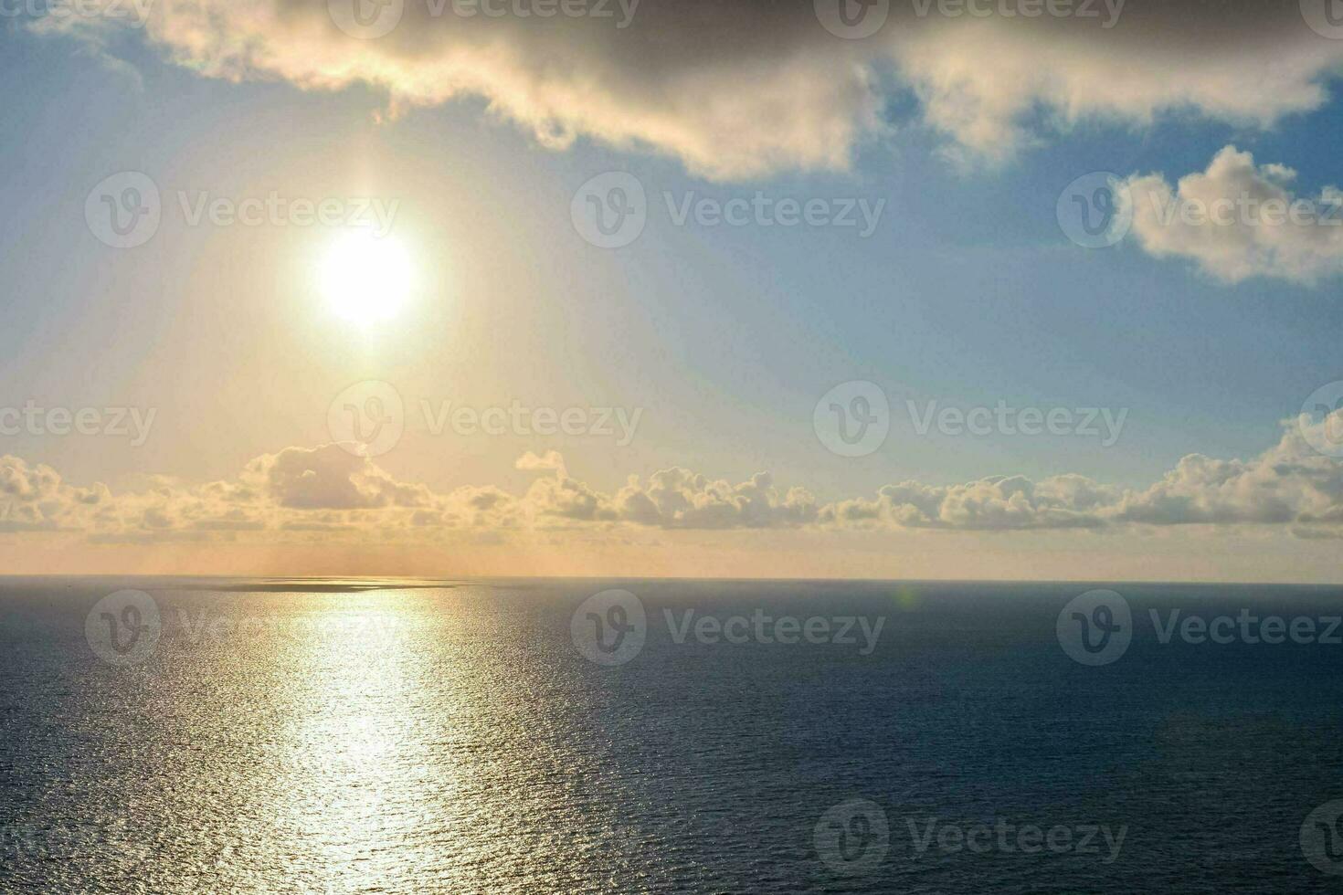 the sun is shining over the ocean photo