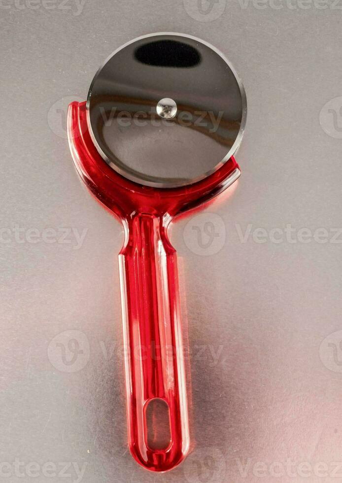 a red plastic pizza cutter photo