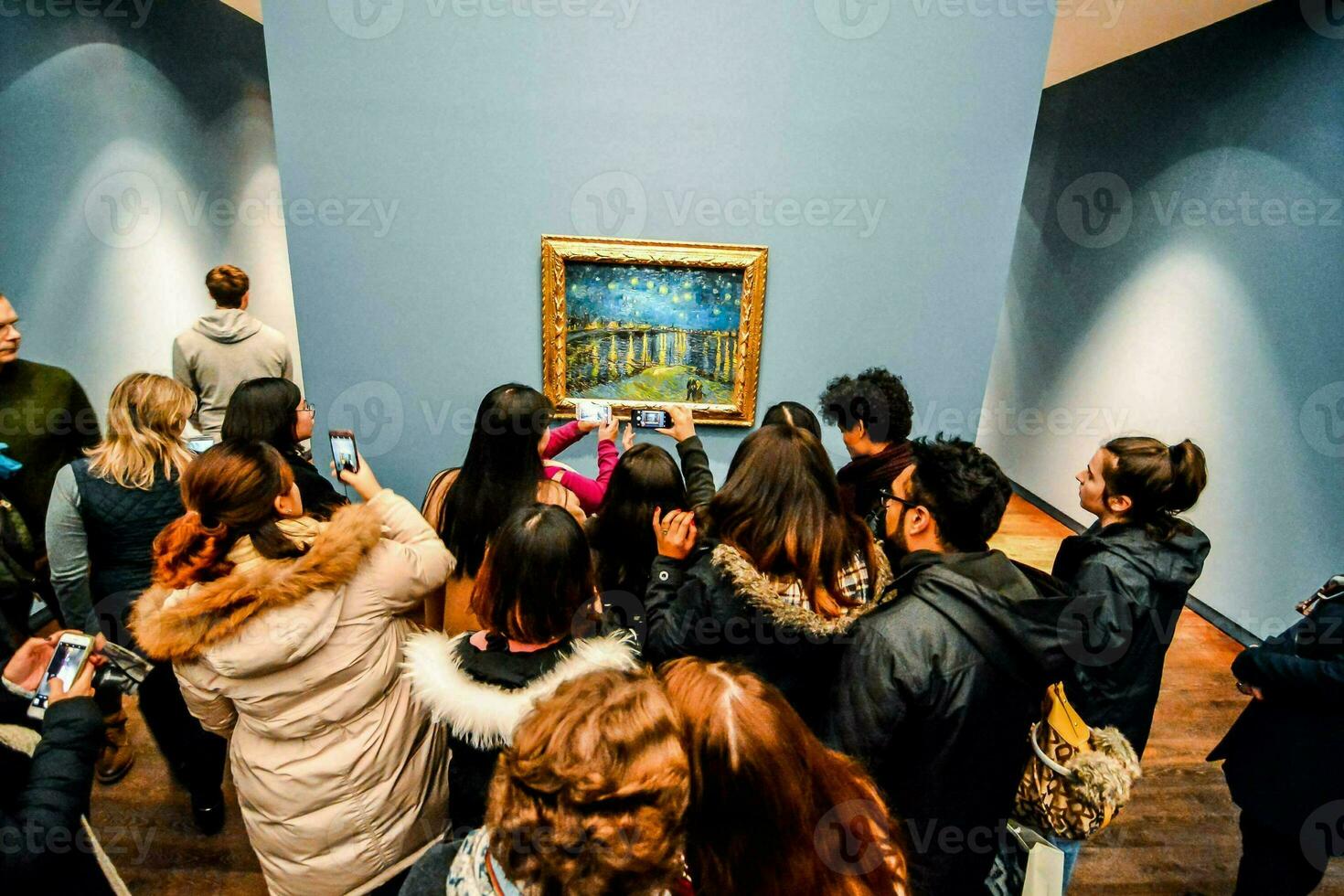 a group of people looking at a painting in an art museum photo