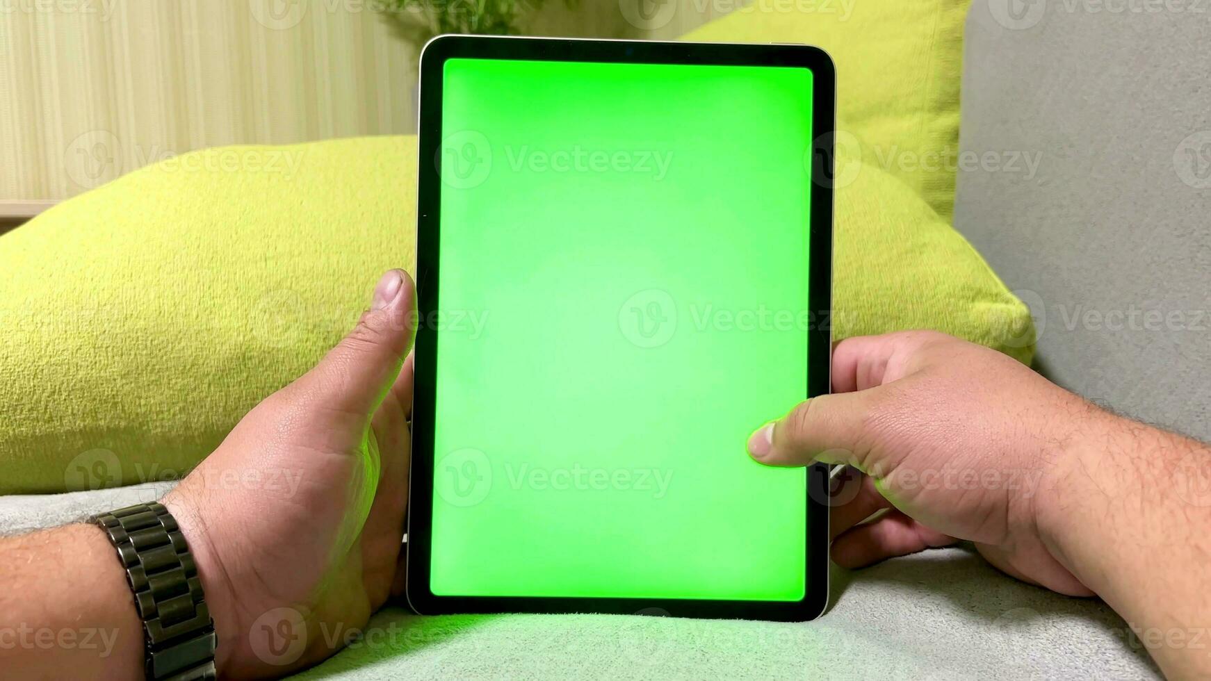 Tablet with green screen in men's hands. Online stores, computer game sites, applications. Chroma key for layout. photo