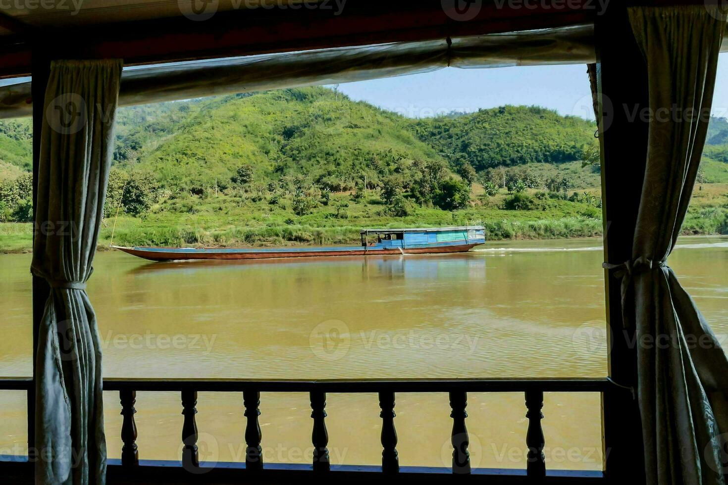 a view of a boat on the mekong river from a window photo