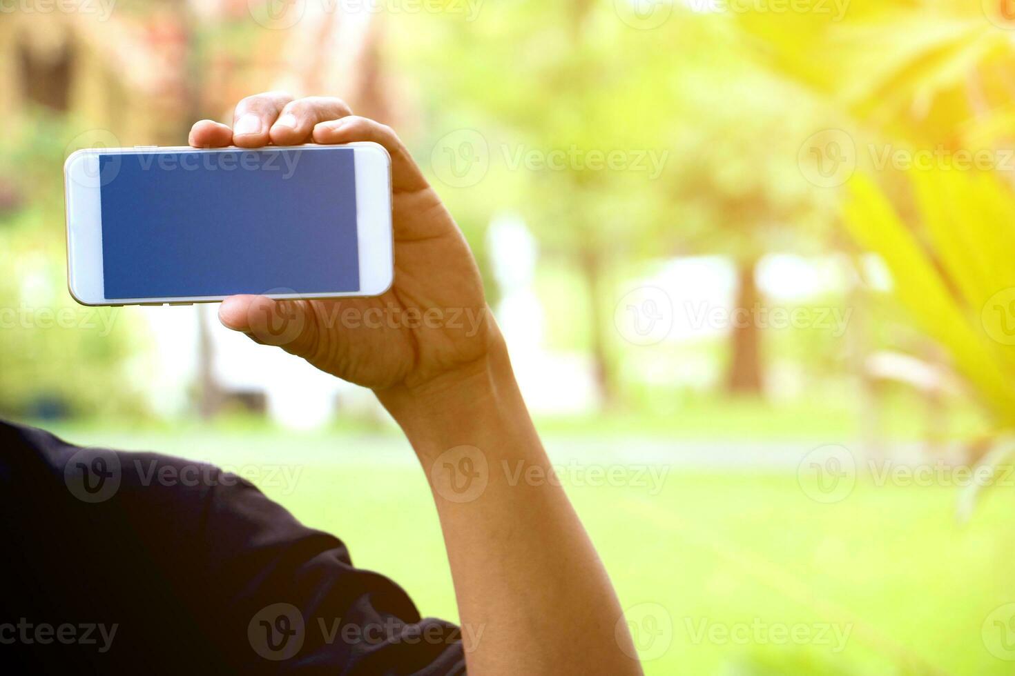 a man holding up a cell phone in front of him photo