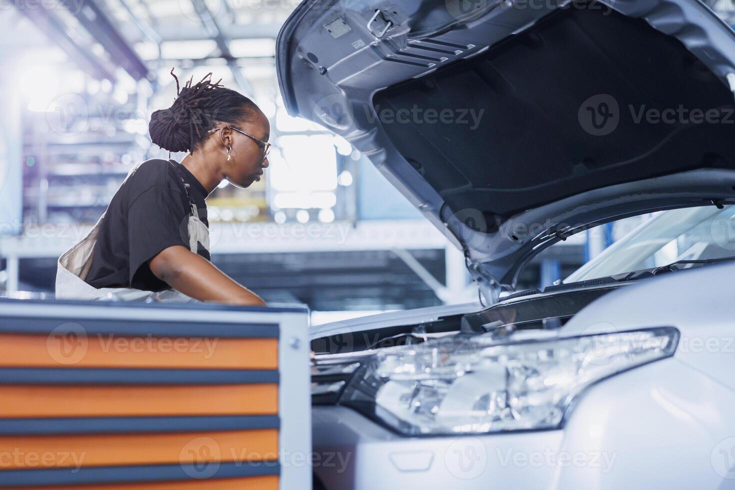Mechanic in car service picks torque wrench from work station bench, using it to tighten bolts after replacing radiator. Trained BIPOC garage worker uses professional tools to fix client automobile photo
