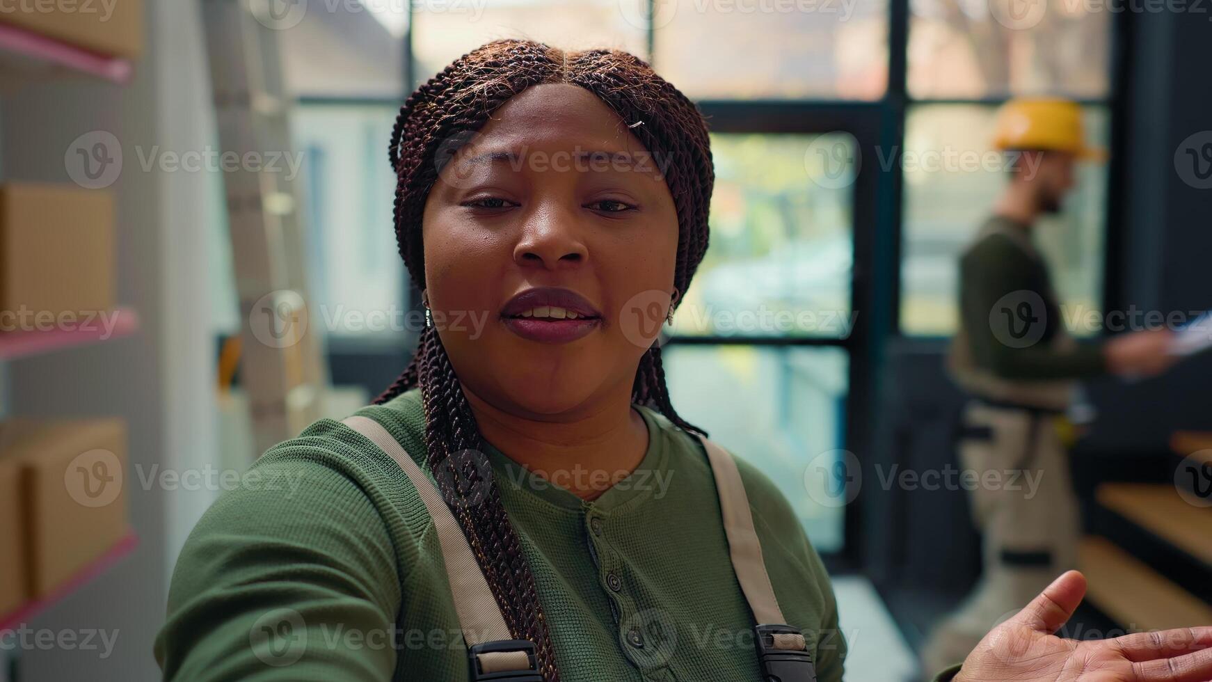 African american warehouse manager using selfie smartphone camera, filming introduction video for new interns starting job in distribution center, teaching them safety measures photo