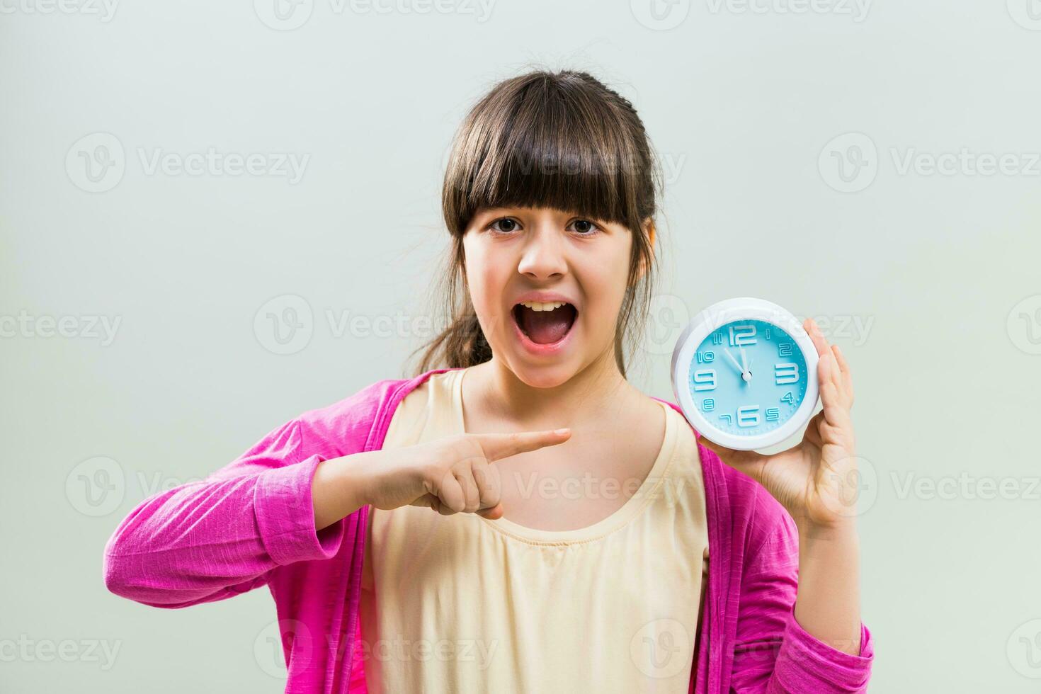 Little girl in panic pointing at clock photo