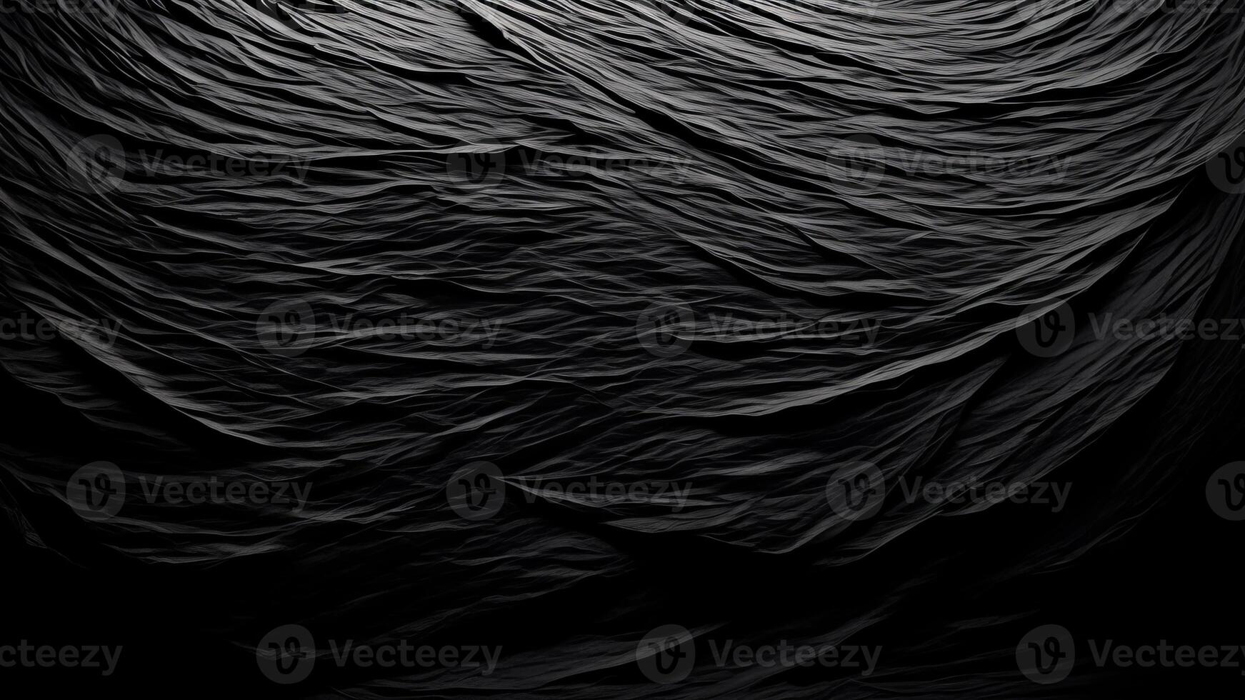 Heavy crumpled black paper texture in low light background. photo