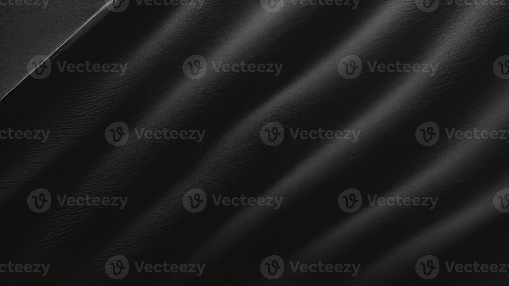 Heavy crumpled black paper texture in low light background. photo