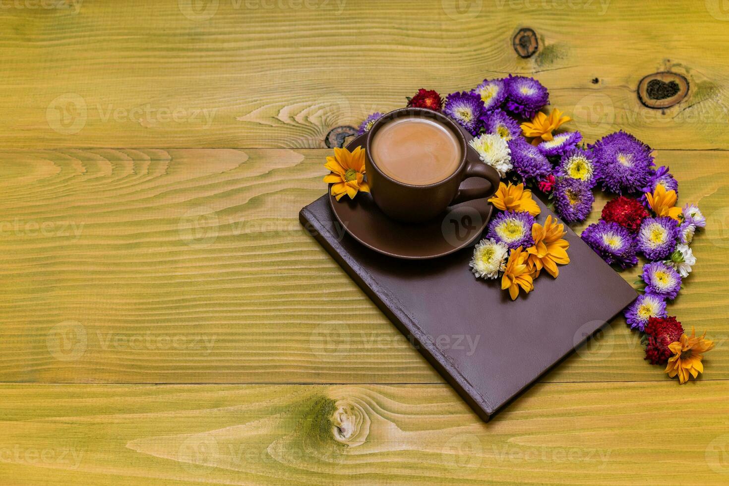 Image of cup of coffee and book with beautiful flowers on wooden background photo