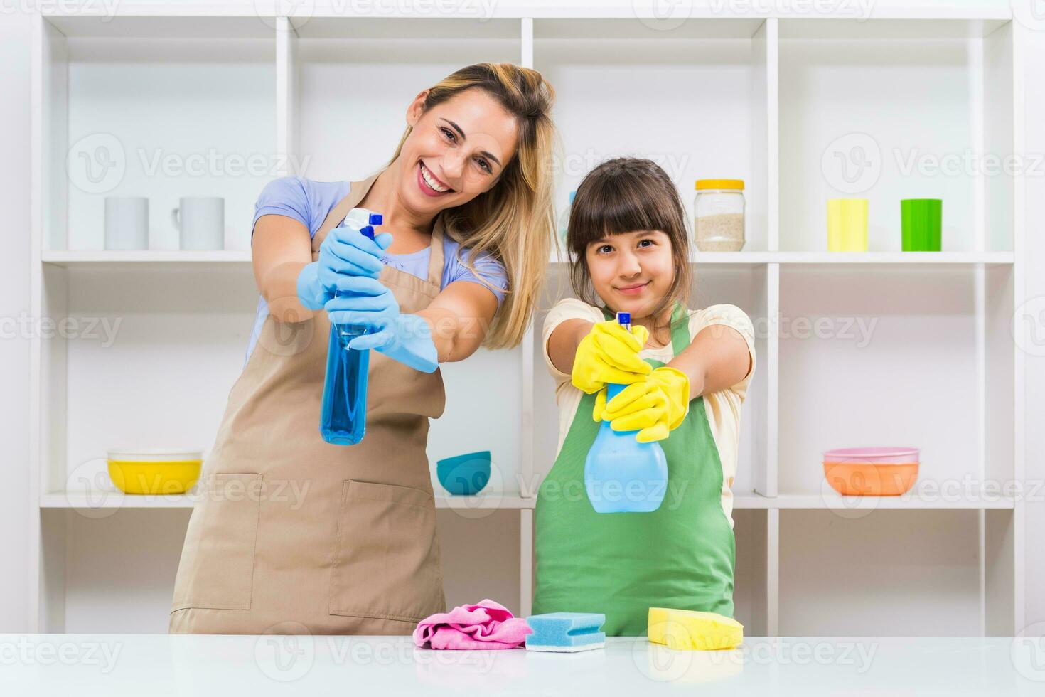Happy mother and her daughter enjoy cleaning and having fun together. photo