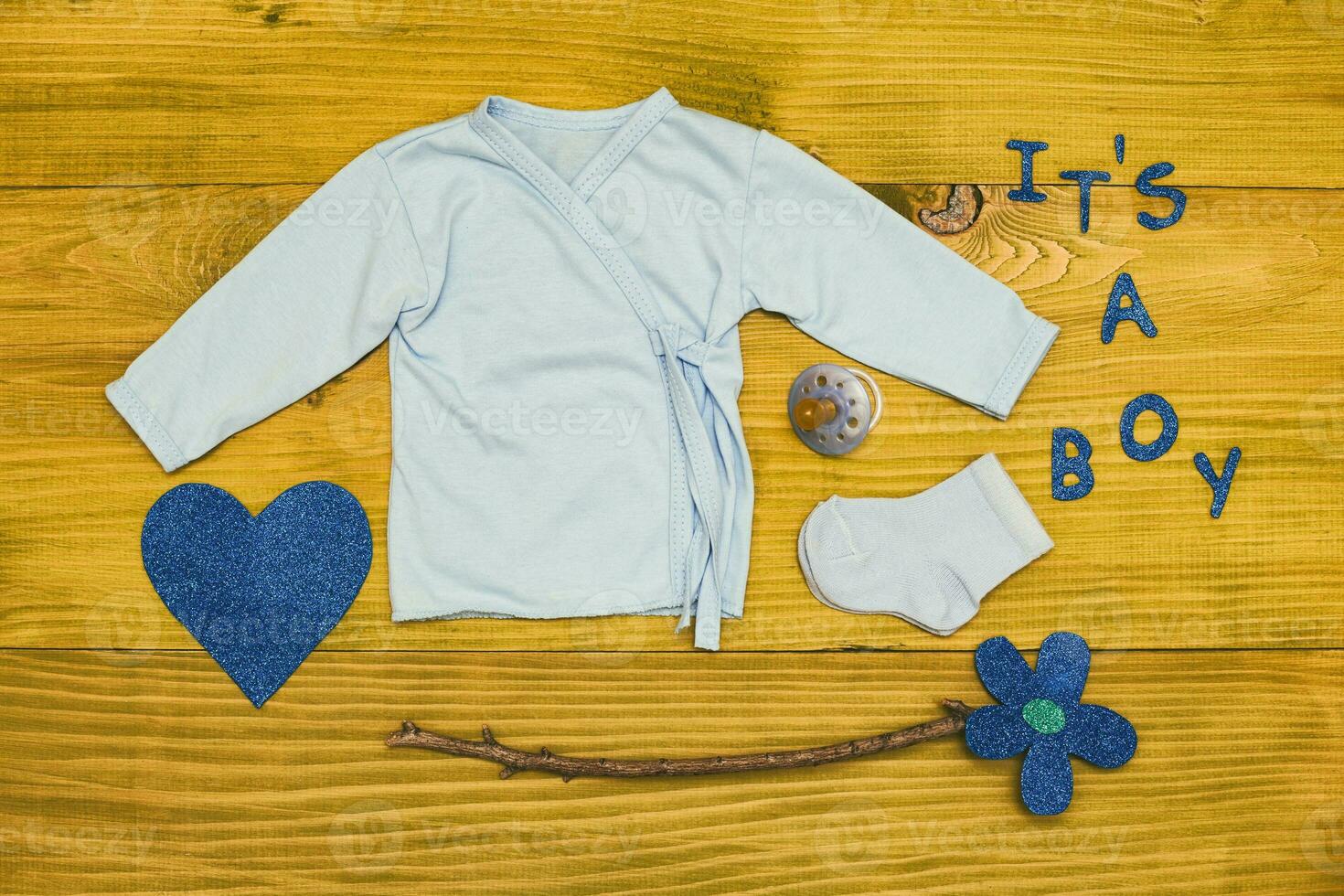 Text it's a boy with baby supplies  on wooden table photo