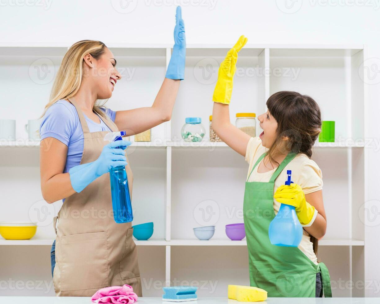 Happy mother and her daughter enjoy cleaning and having fun together. photo