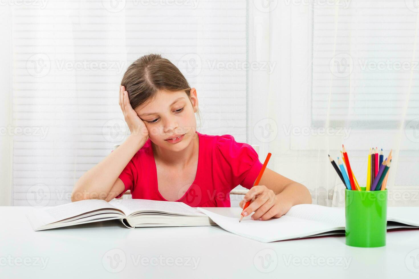 Little girl must stay at home and do her homework,but she would rather play outside. photo
