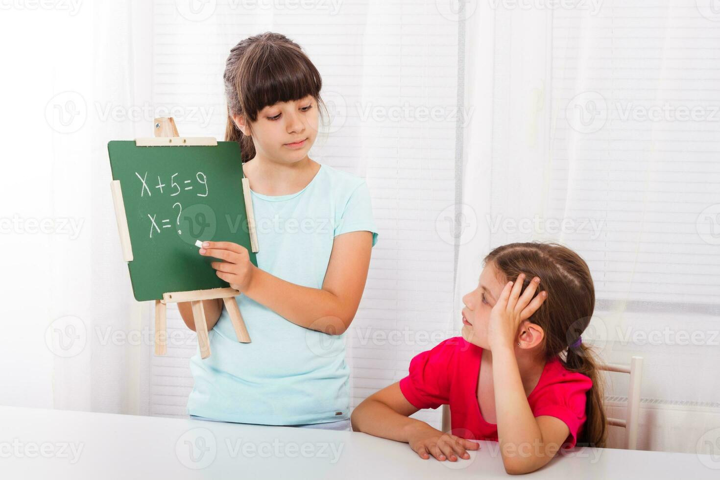 Cute little girls are helping each other with homework photo