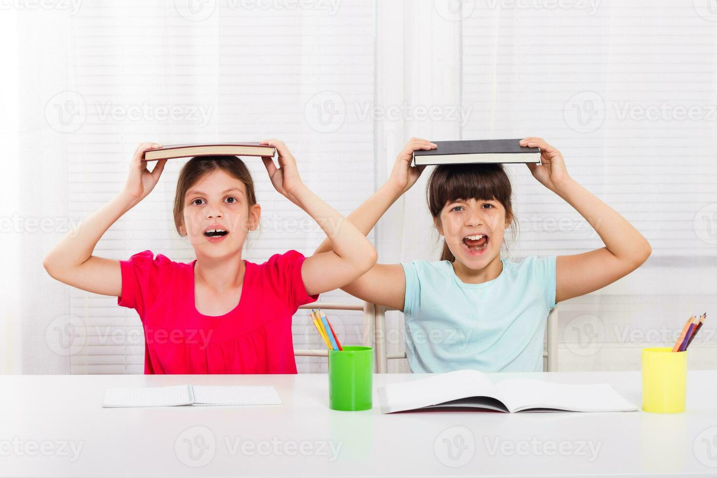 Angry little girls are screaming because they must stay at home and do their homework,but they would rather play outside. photo