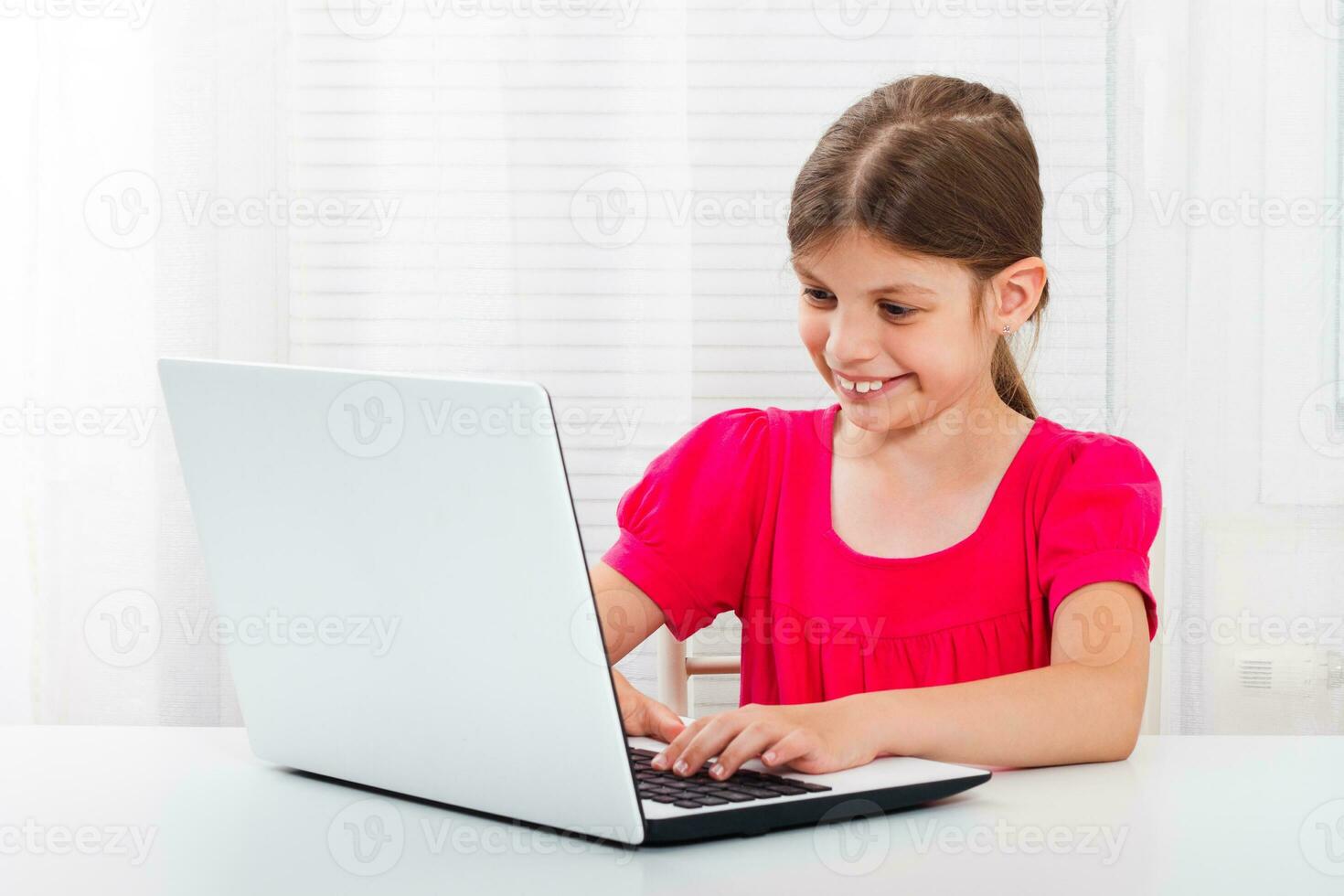 Cute little girl is using laptop photo