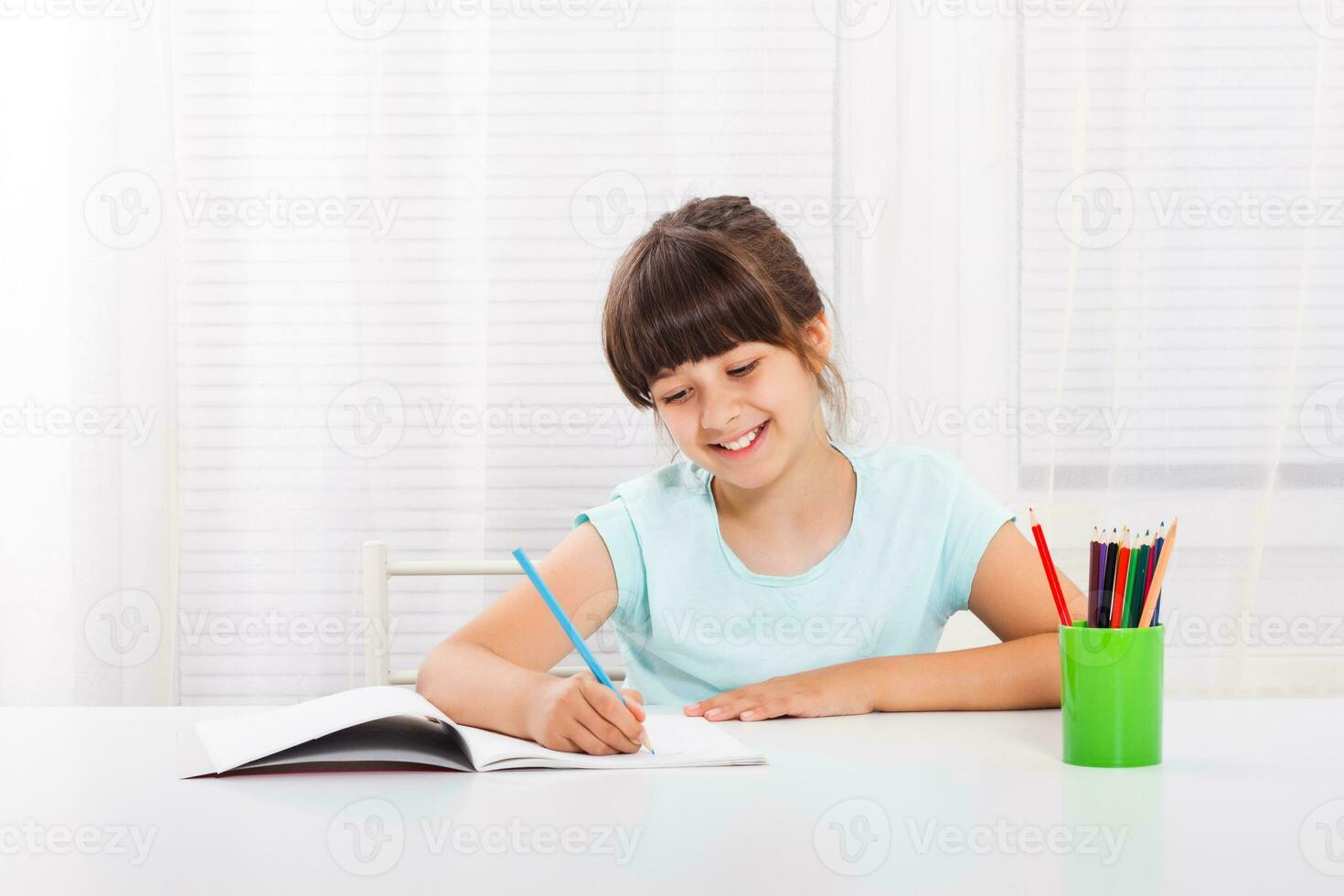Cute little girl is doing her homework photo