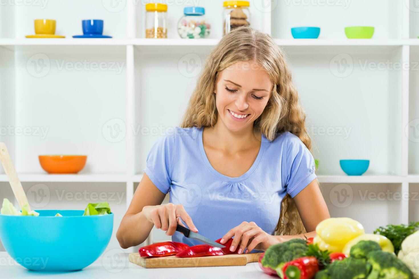 Beautiful girl enjoys making healthy meal at her home photo