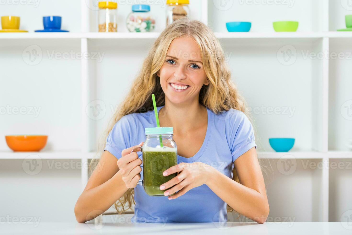 Beautiful girl enjoys drinking smoothie at her home photo