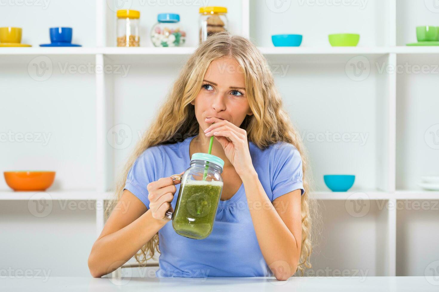 Beautiful girl enjoys drinking smoothie at her home photo