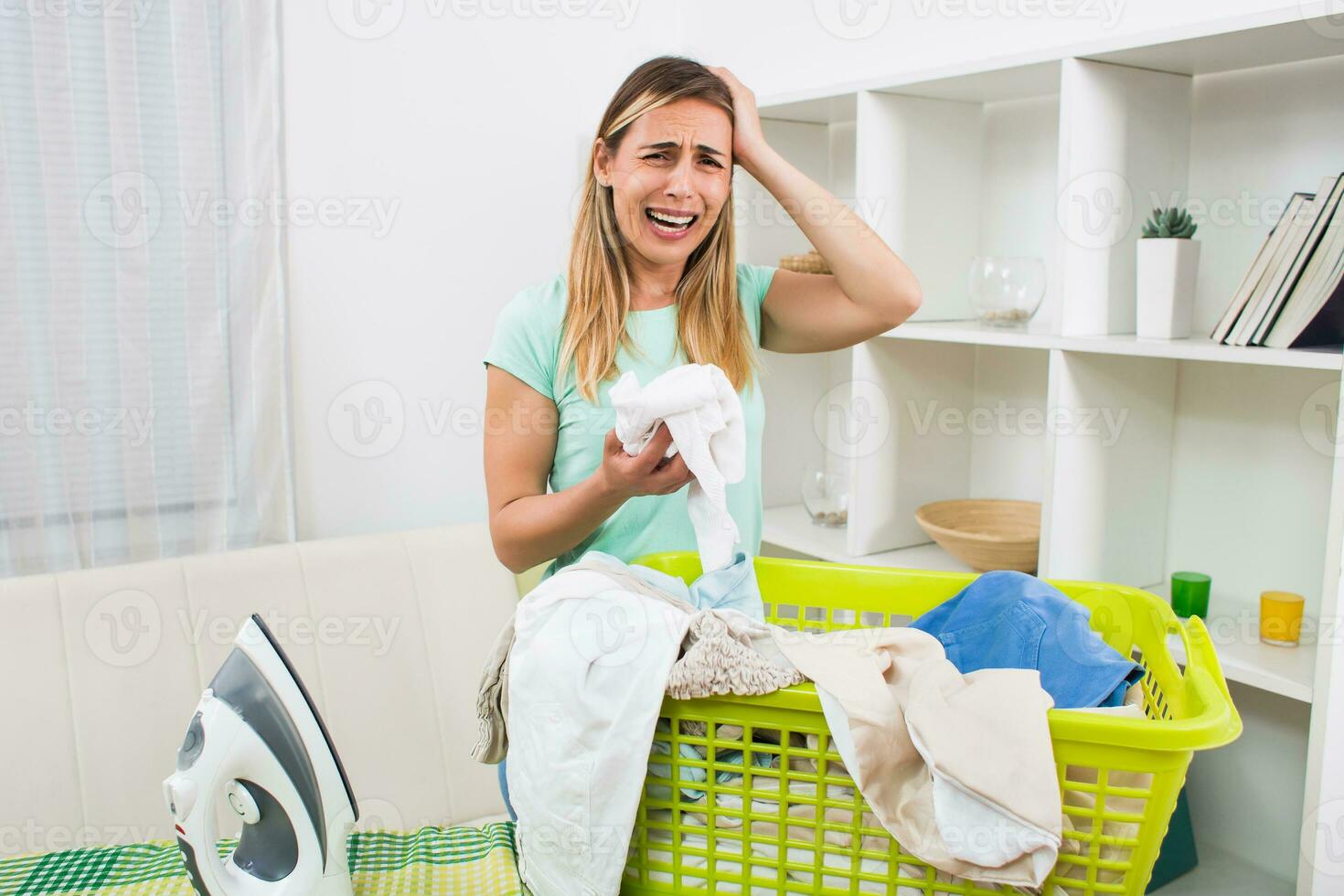 Woman is displeased because she has got to much laundry for ironing photo