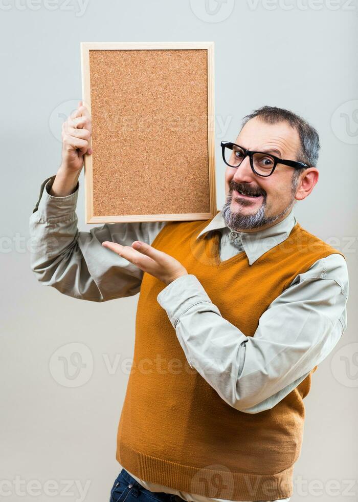 Nerdy businessman is showing empty cork board photo
