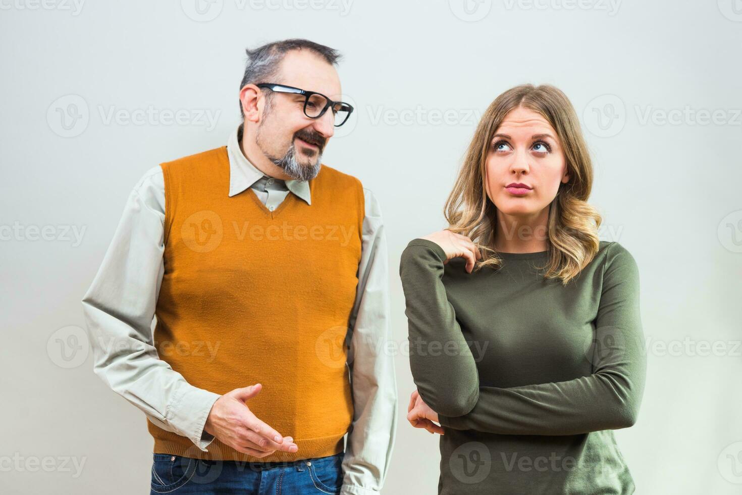 Nerdy man is trying to get beautiful woman's attention but she is not interested and angry ignore him photo