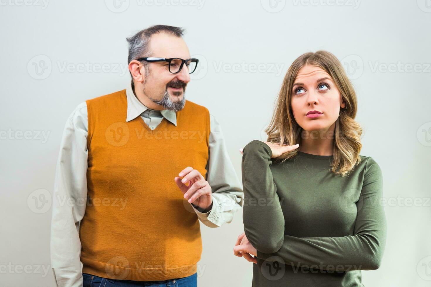 Nerdy man is trying to get beautiful woman's attention but she is not interested and angry ignore him photo