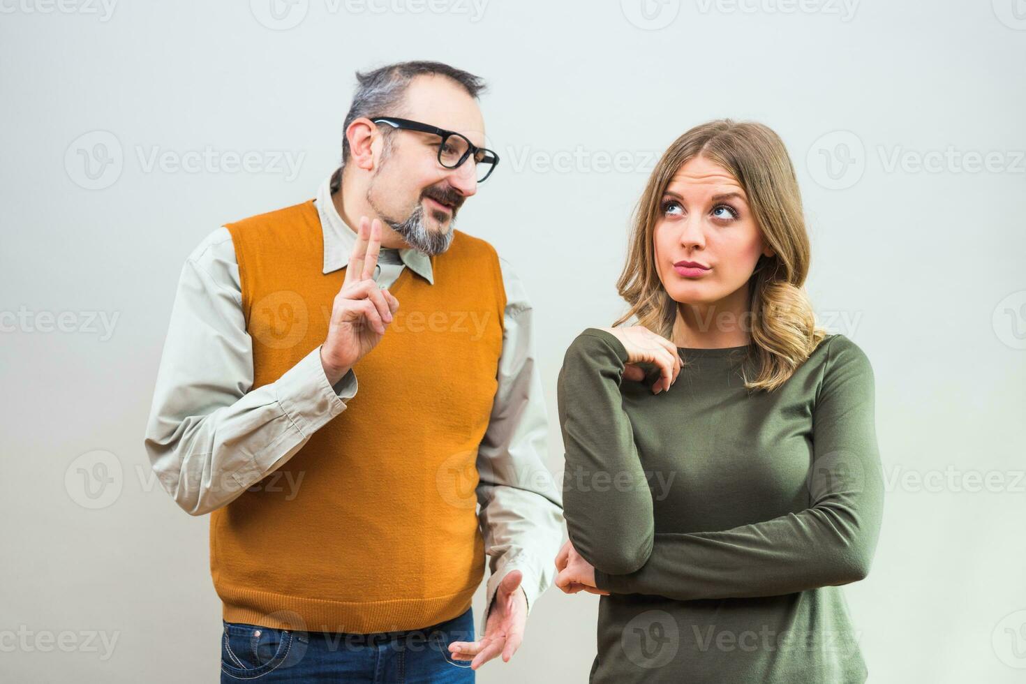 Nerdy man is trying to get beautiful woman's attention but she is not interested and angry ignore him photo