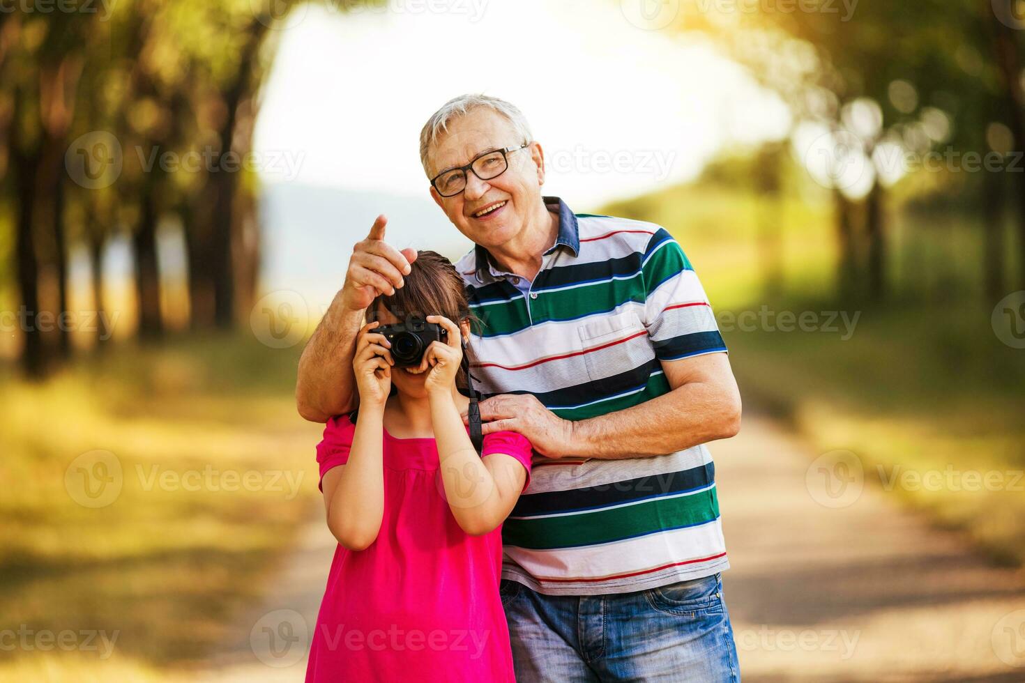 abuelo y nieta fotografiando en el naturaleza juntos foto