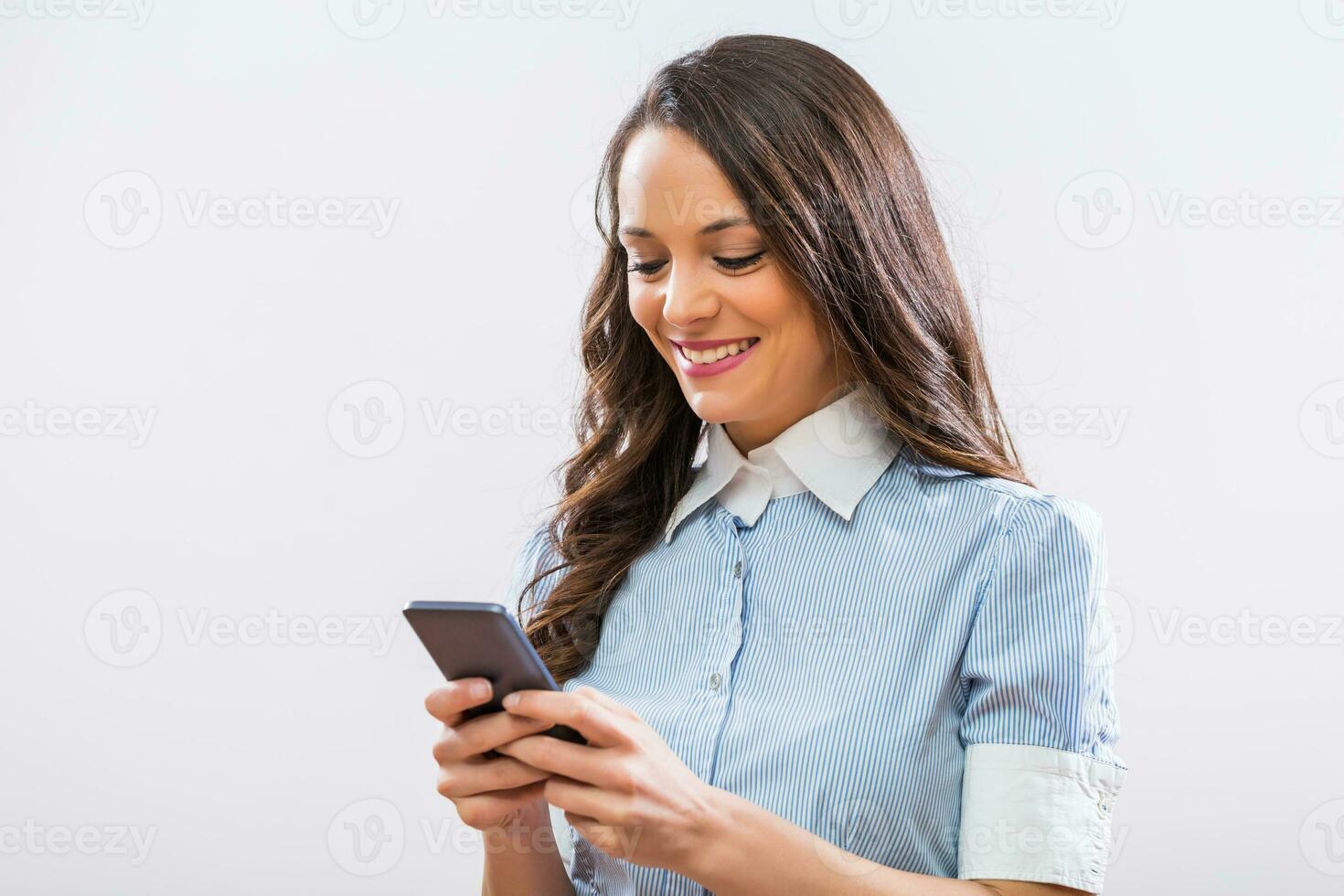 Image of beautiful businesswoman using phone on gray background photo