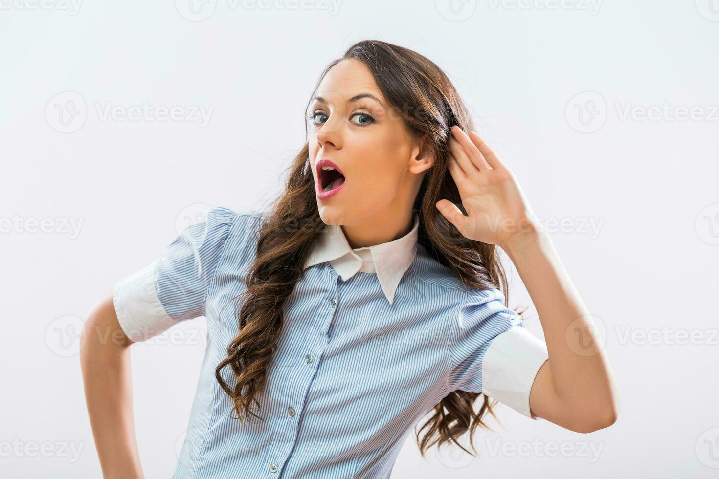 Image of beautiful businesswoman listening something on gray background photo