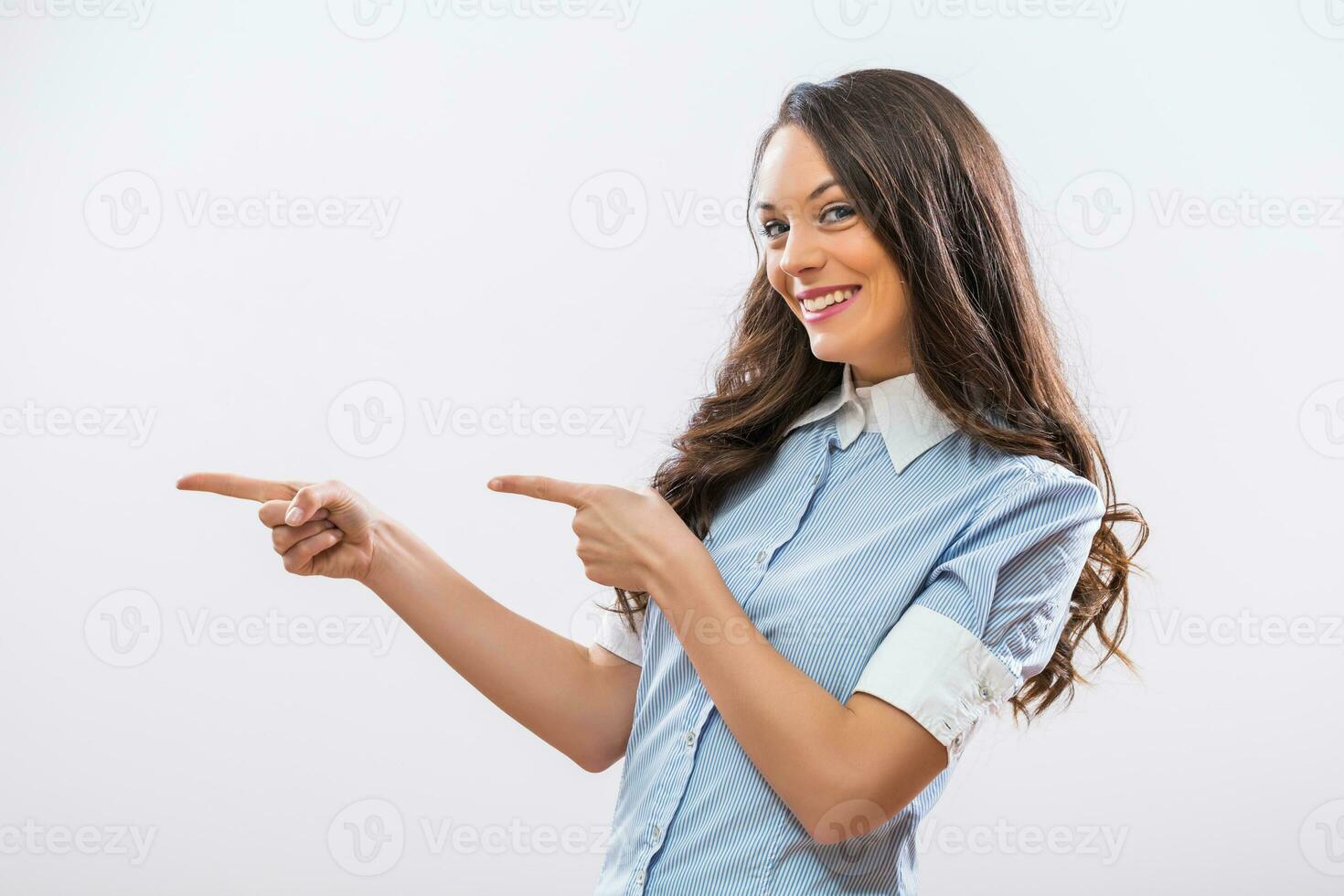 Image of beautiful businesswoman pointing on gray background photo