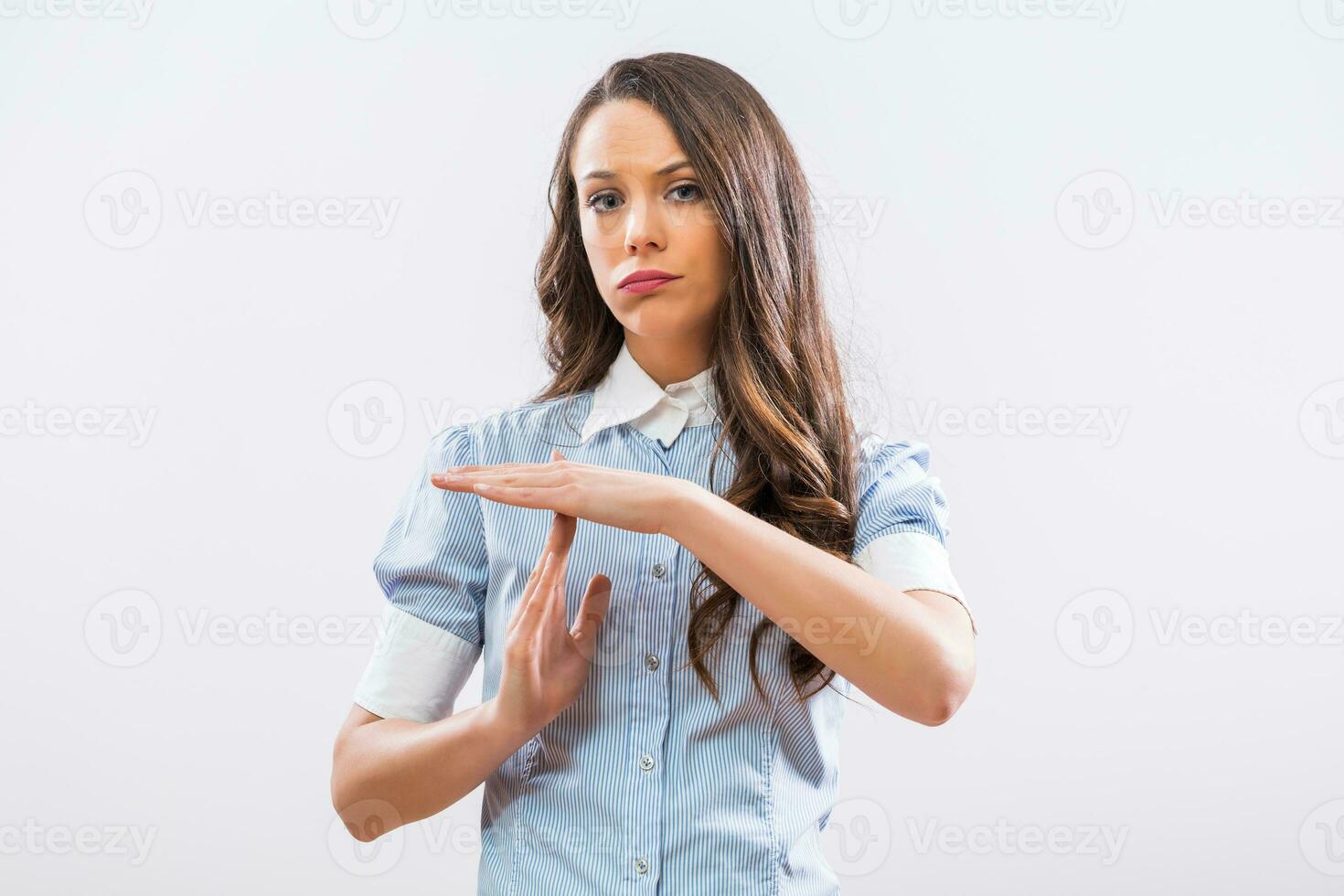 Image of tired businesswoman showing time out sign on gray background photo