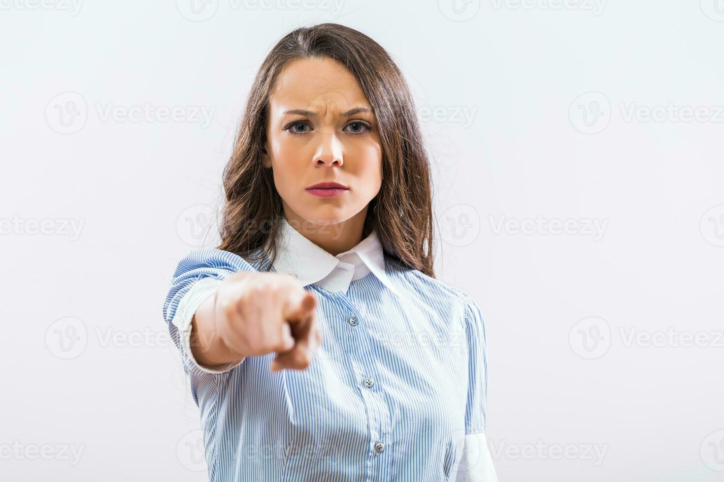Image of angry businesswoman pointing on gray background photo