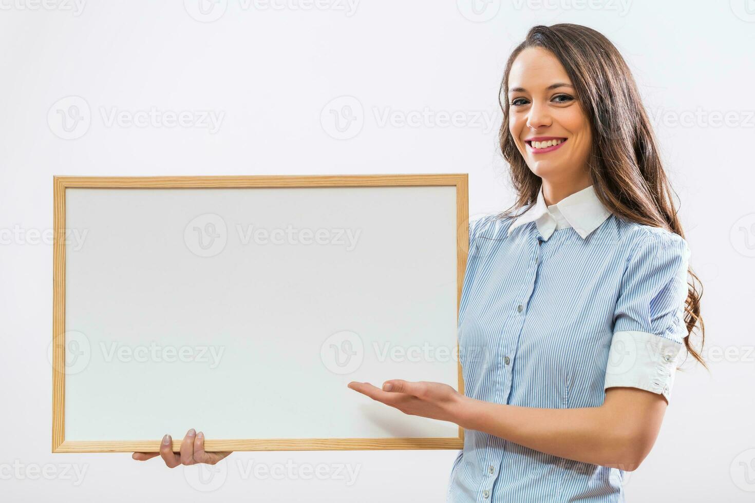 Beautiful businesswoman showing whiteboard on gray background photo