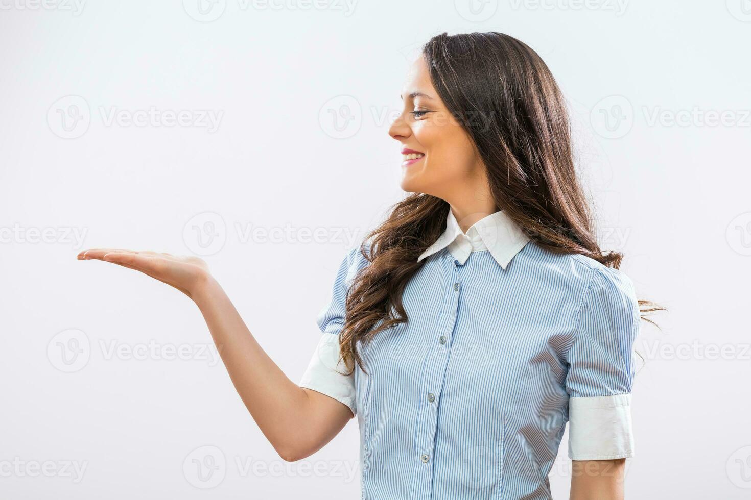 Image of beautiful businesswoman showing palm of hand on gray background photo