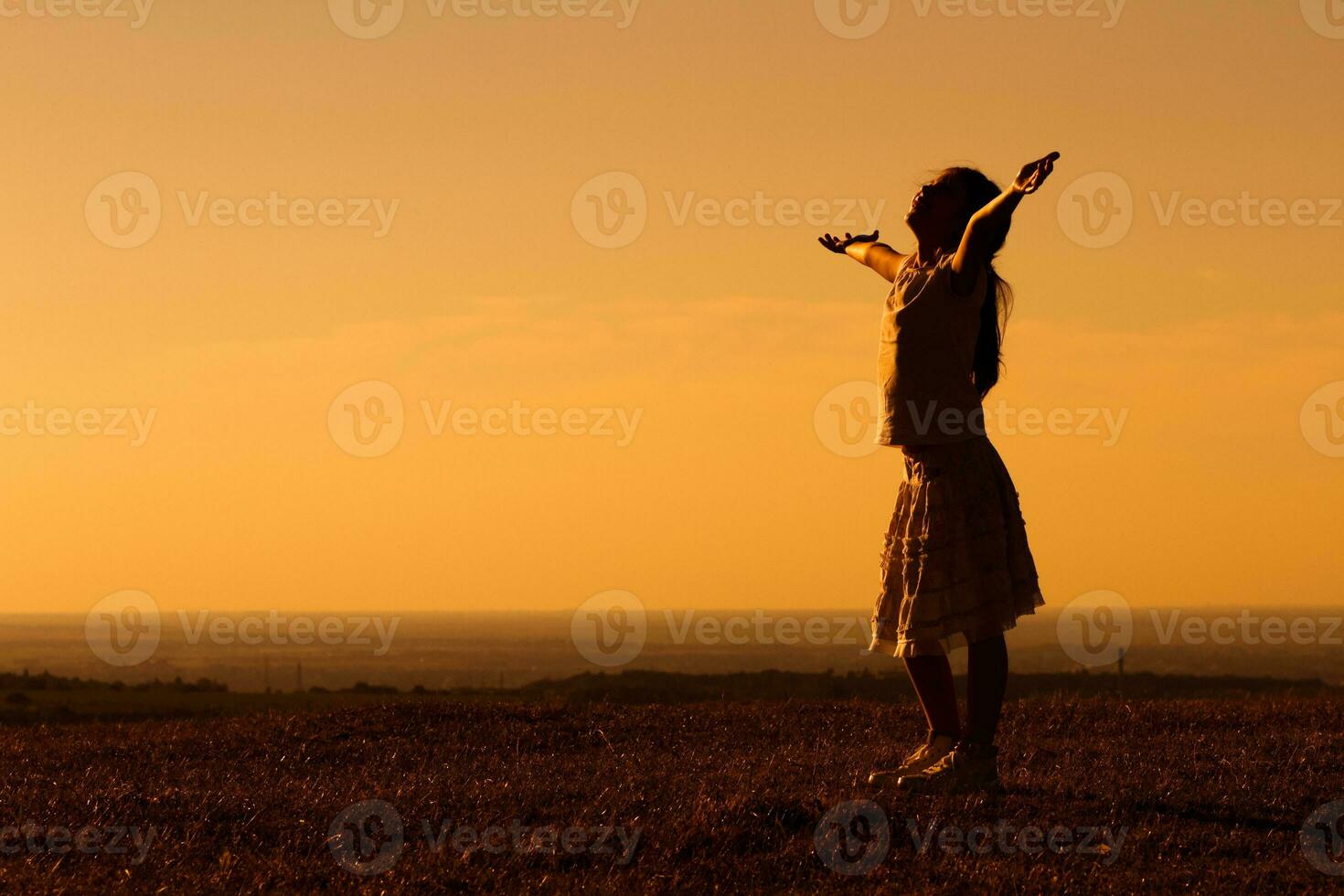 silueta de pequeño niña saludo el puesta de sol foto