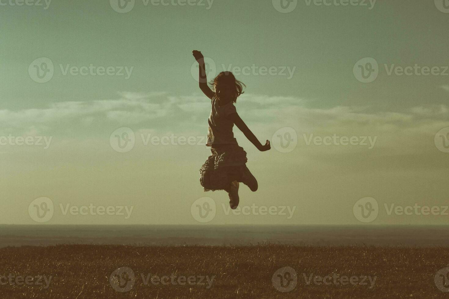 Happy little girl jumping in the nature photo