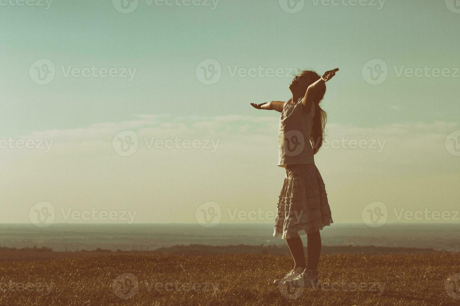 silueta de pequeño niña saludo el puesta de sol foto