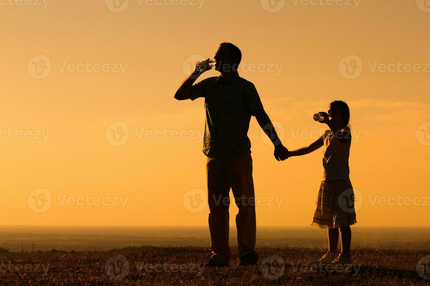 Father and daughter drinking water in nature photo