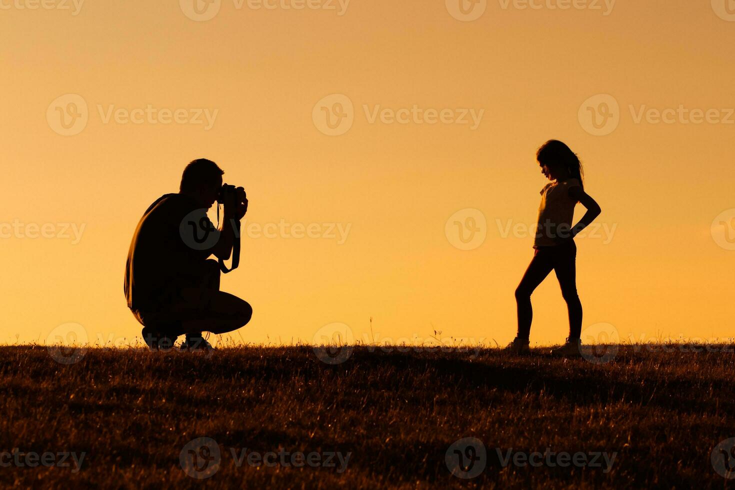 Silhouette of a father photographing daughter photo