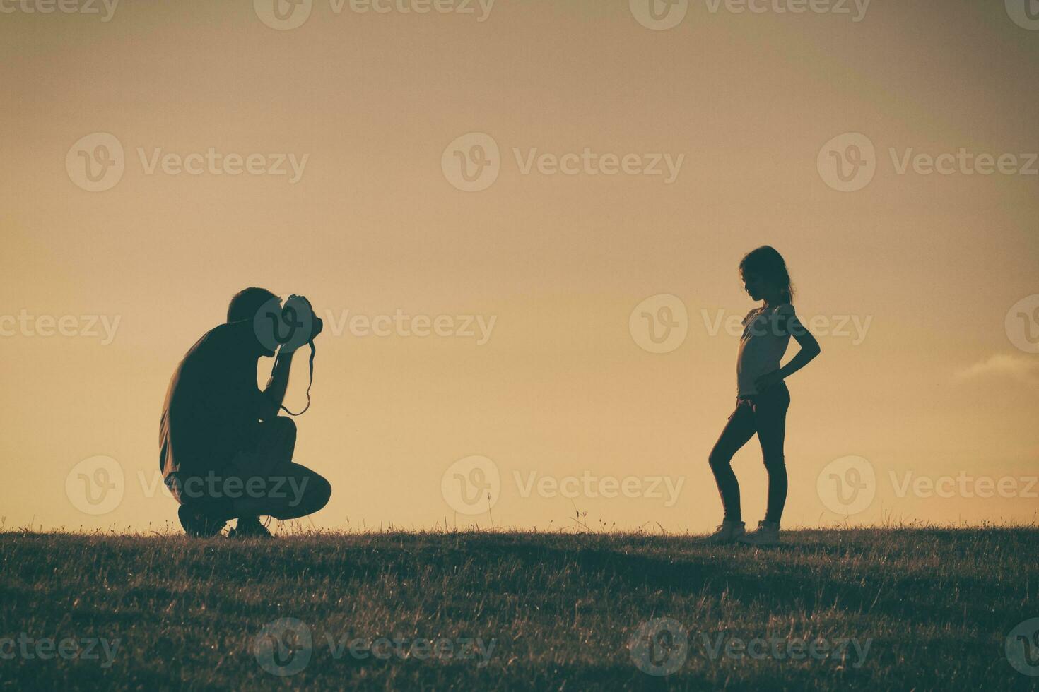 Silhouette of a father photographing daughter photo