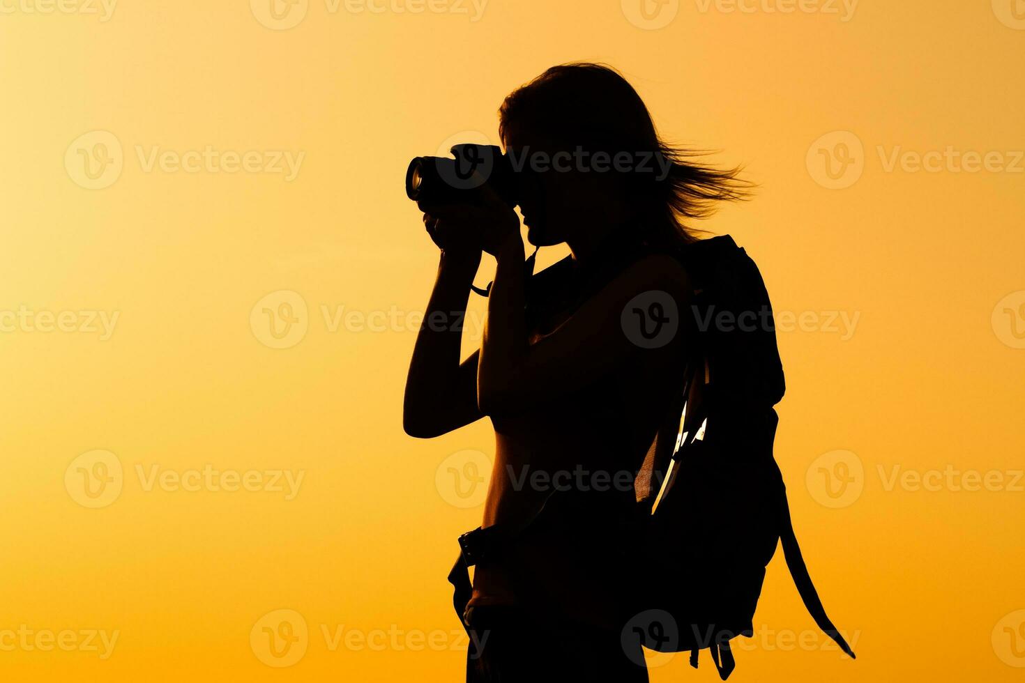 Silhouette of a woman hiker  photographing photo