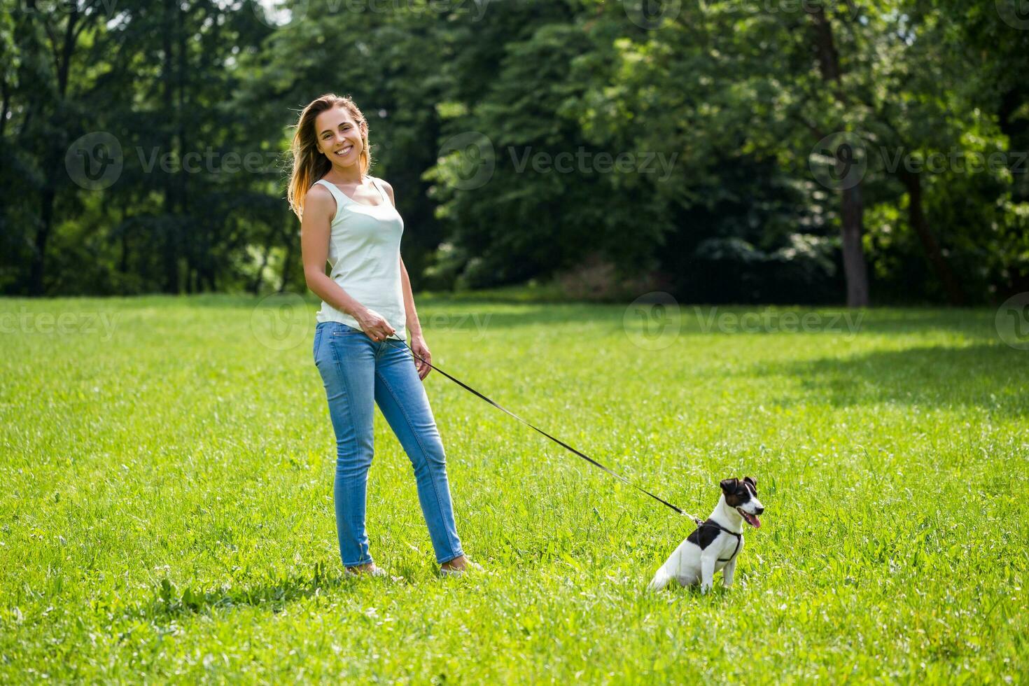 Beautiful woman enjoys walking with her cute dog Jack Russell Terrier in the nature. photo