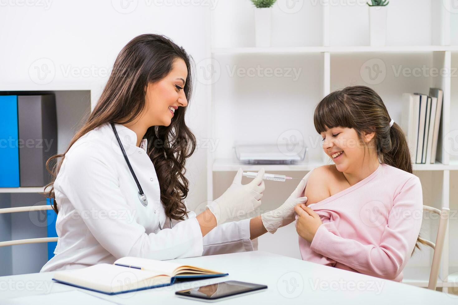 Female doctor giving injection to a child at medical office photo